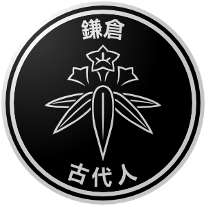 The logo of the Kamakura Kodaibito (Ancients): a black circle, bordered in white-black-white, on which Kamakura's emblem, the white outline of bamboo gentian, sits between the characters for "Kamakura" and the one for "Ancients."
