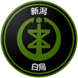 The logo of the Niigata Hakucho (Swans): a black circle, bordered in leaf-black-leaf, on which Niigata's emblem—supposedly a representation of a character from the city's name—sits in leaf green, bordered by the characters for "Niigata" and "Hakuchoh" along the edges.
